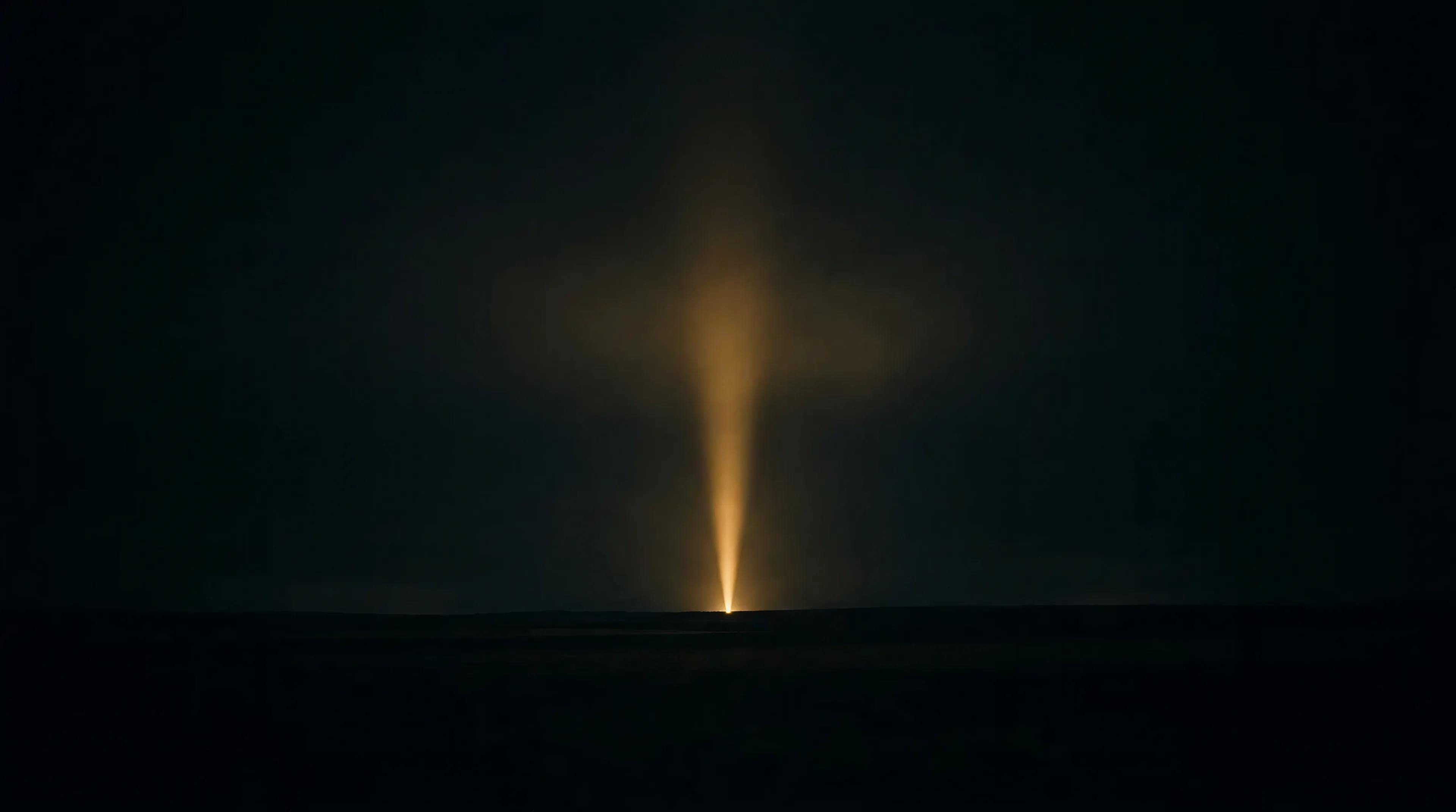 A single warm golden beam of light rising from a dark horizon